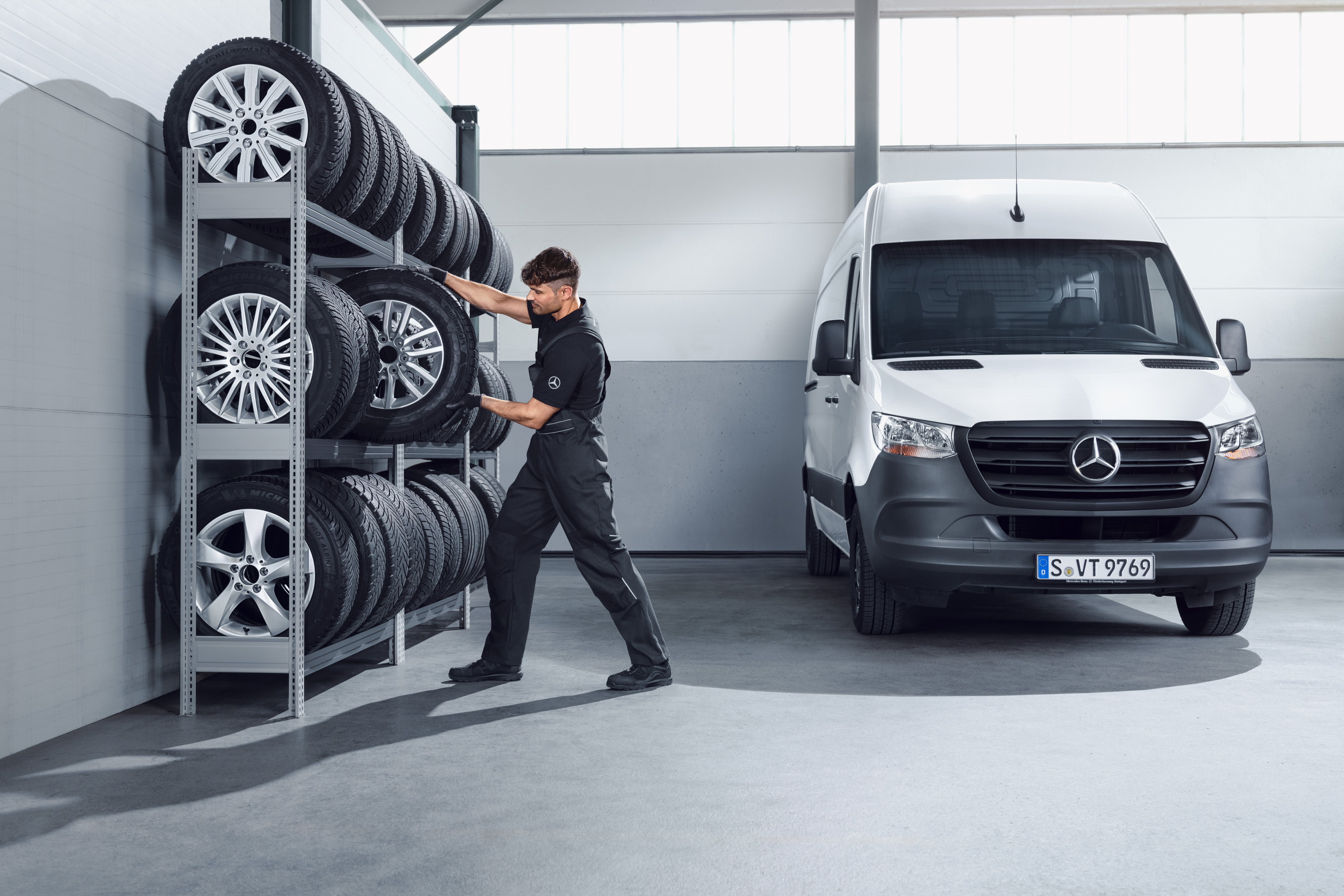 Mercedes-Benz | Vans Quality originele onderdelen Monteur selecteert Mercedes-Benz complete winterwielen voor een witte Sprinter uit het werkplaatsrek.