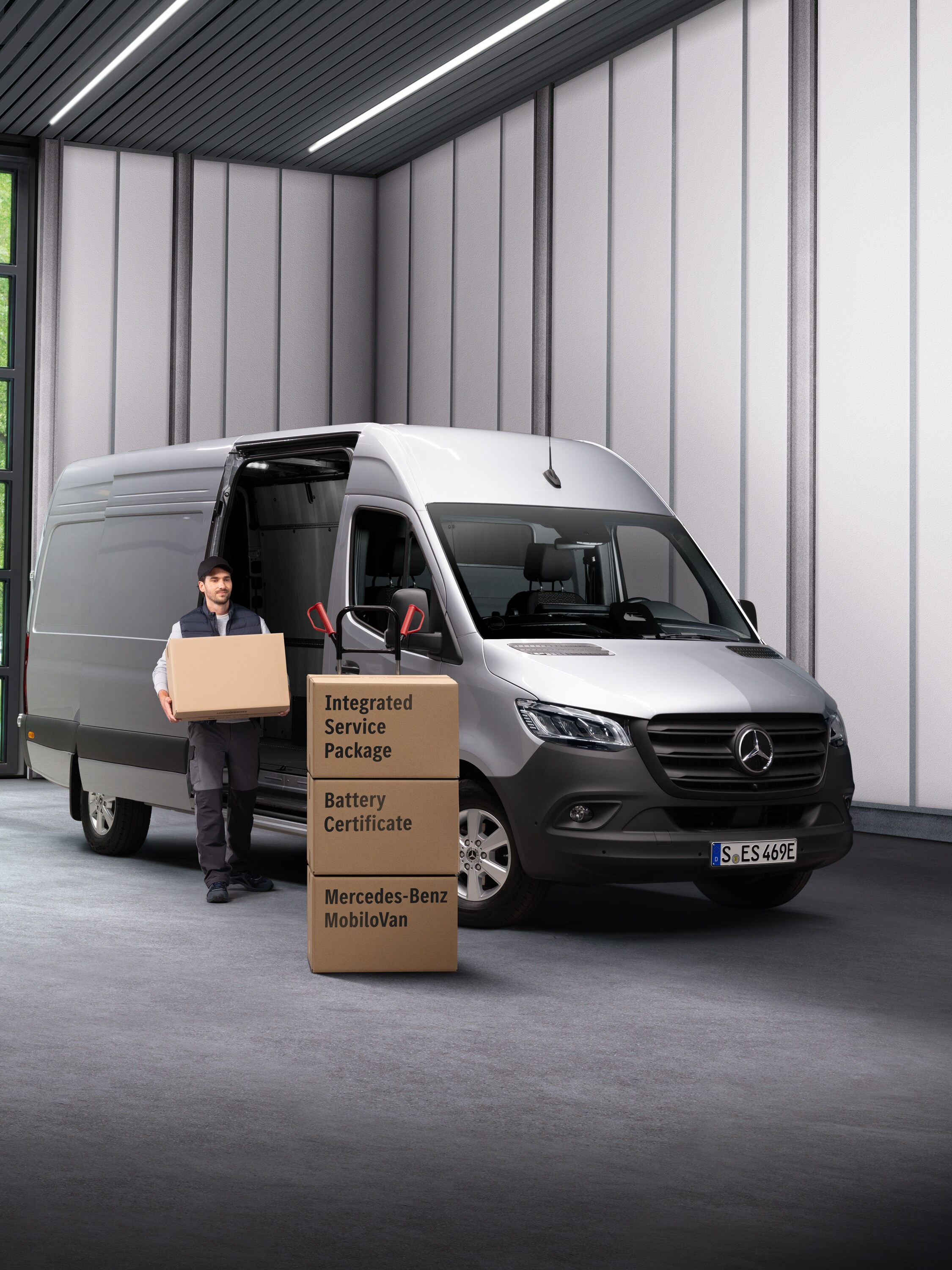 Een Mercedes-Benz servicemedewerker voor elektrische voertuigen die dozen uit een transport draagt.
