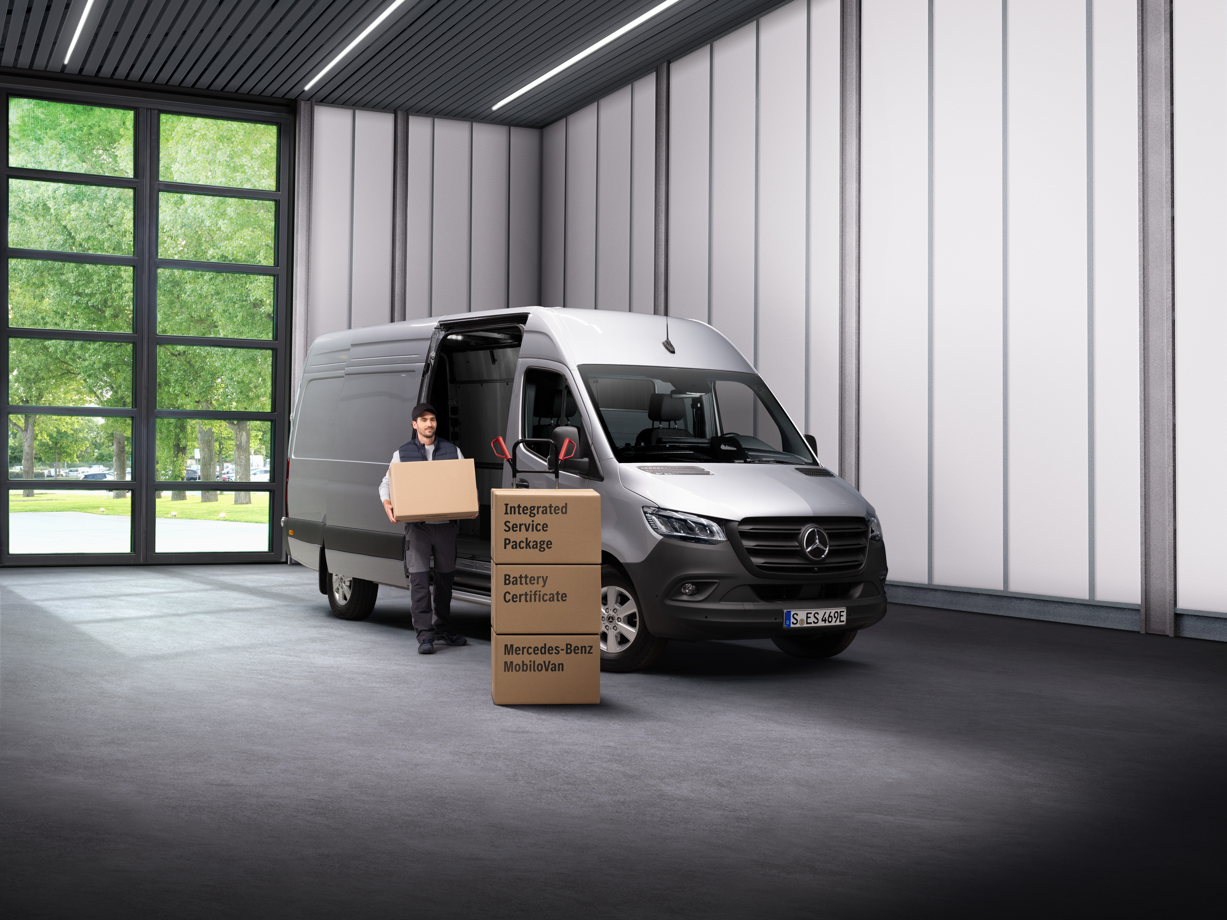 Mercedes-Benz | Service voor elektrische voertuigen Een Mercedes-Benz servicemedewerker voor elektrische voertuigen die dozen uit een transport draagt.