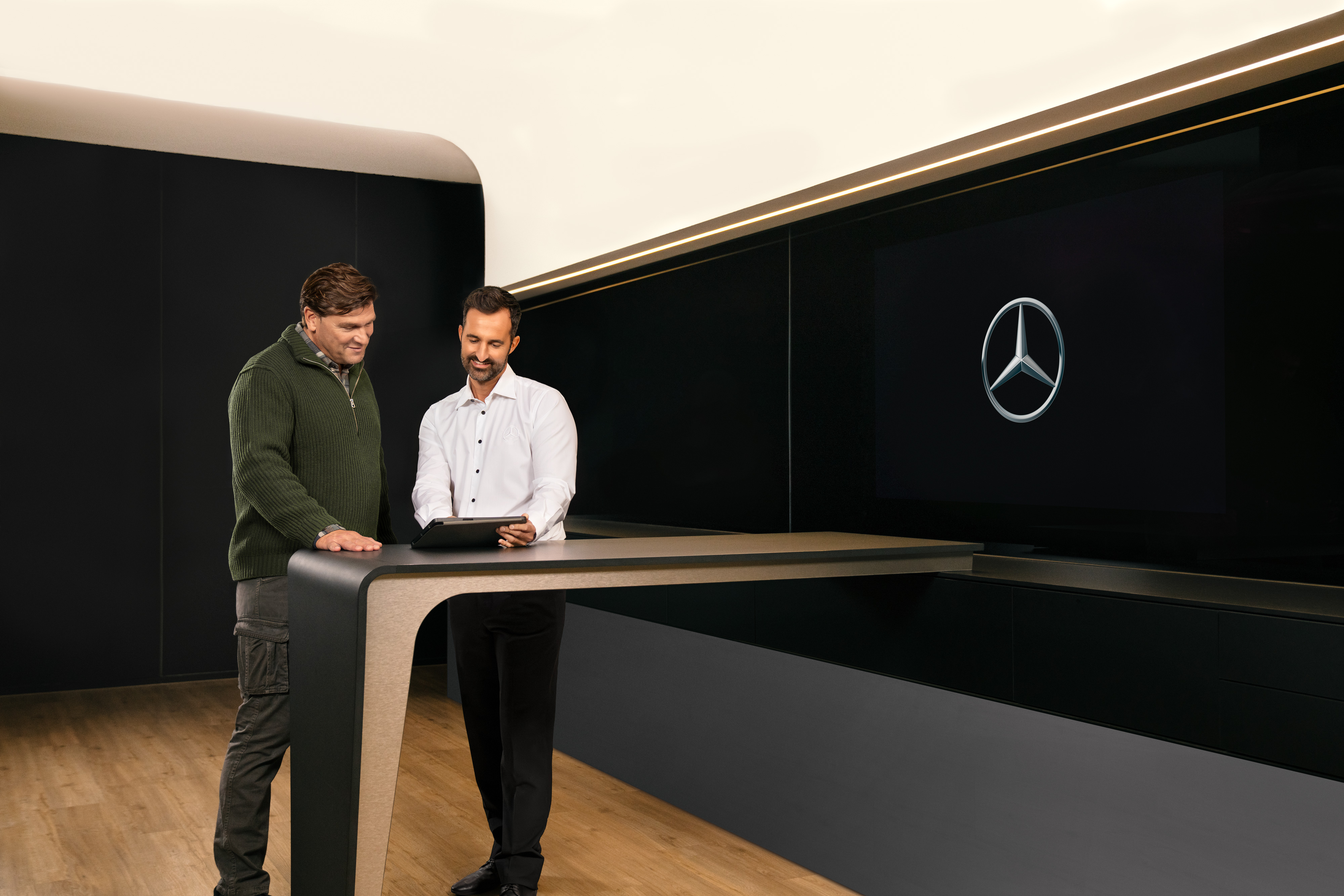 Mercedes-Benz Bedrijfswagens | ServiceCare Twee mannen bespreken Mercedes-Benz ServiceCare pakketten voor bedrijfswagens via een tablet.