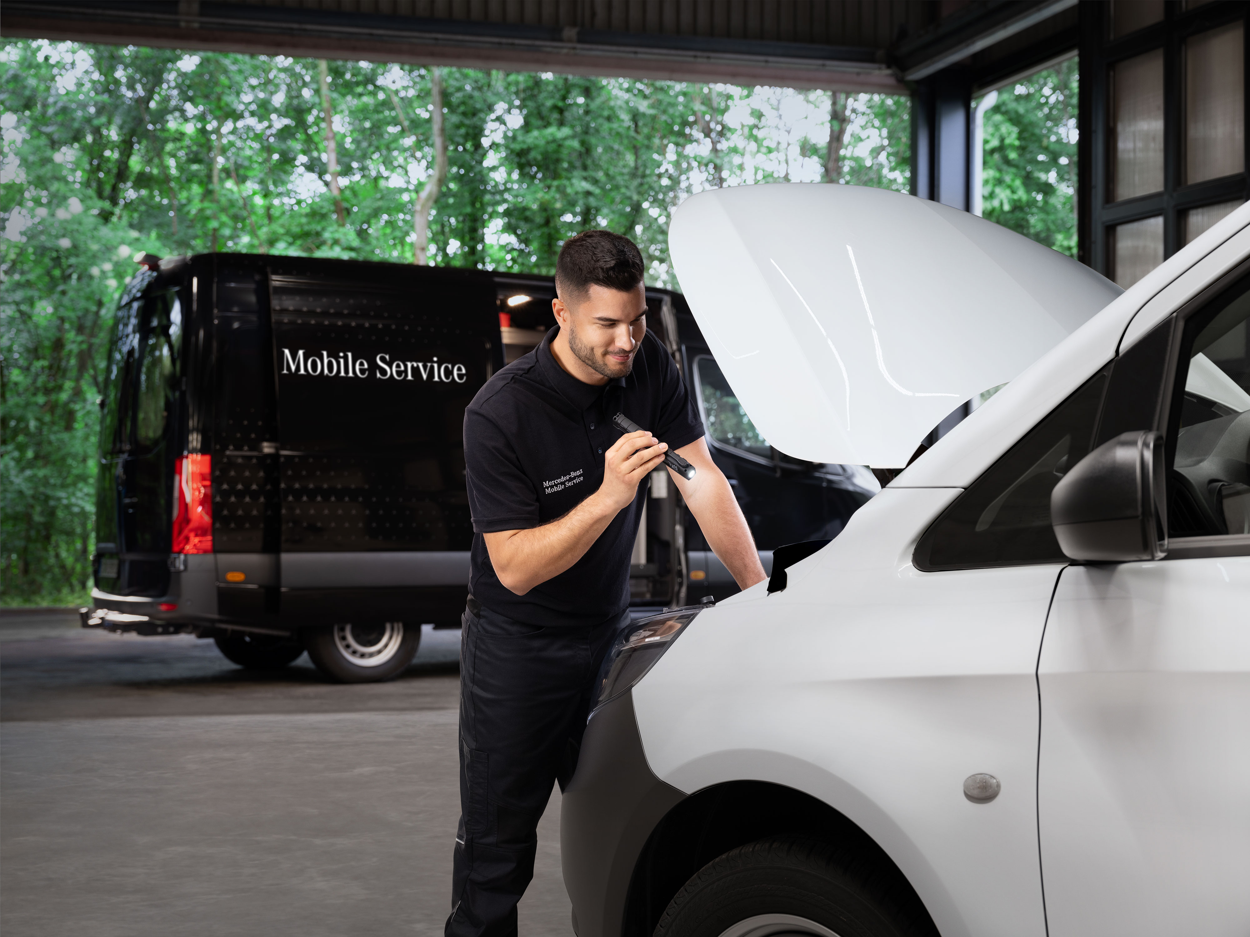 Mercedes-Benz Bedrijfswagens | Onderhoud Mobiele Service Monteur inspecteert de motor van een witte Mercedes-Benz bedrijfswagen als symbool voor mobiele service.