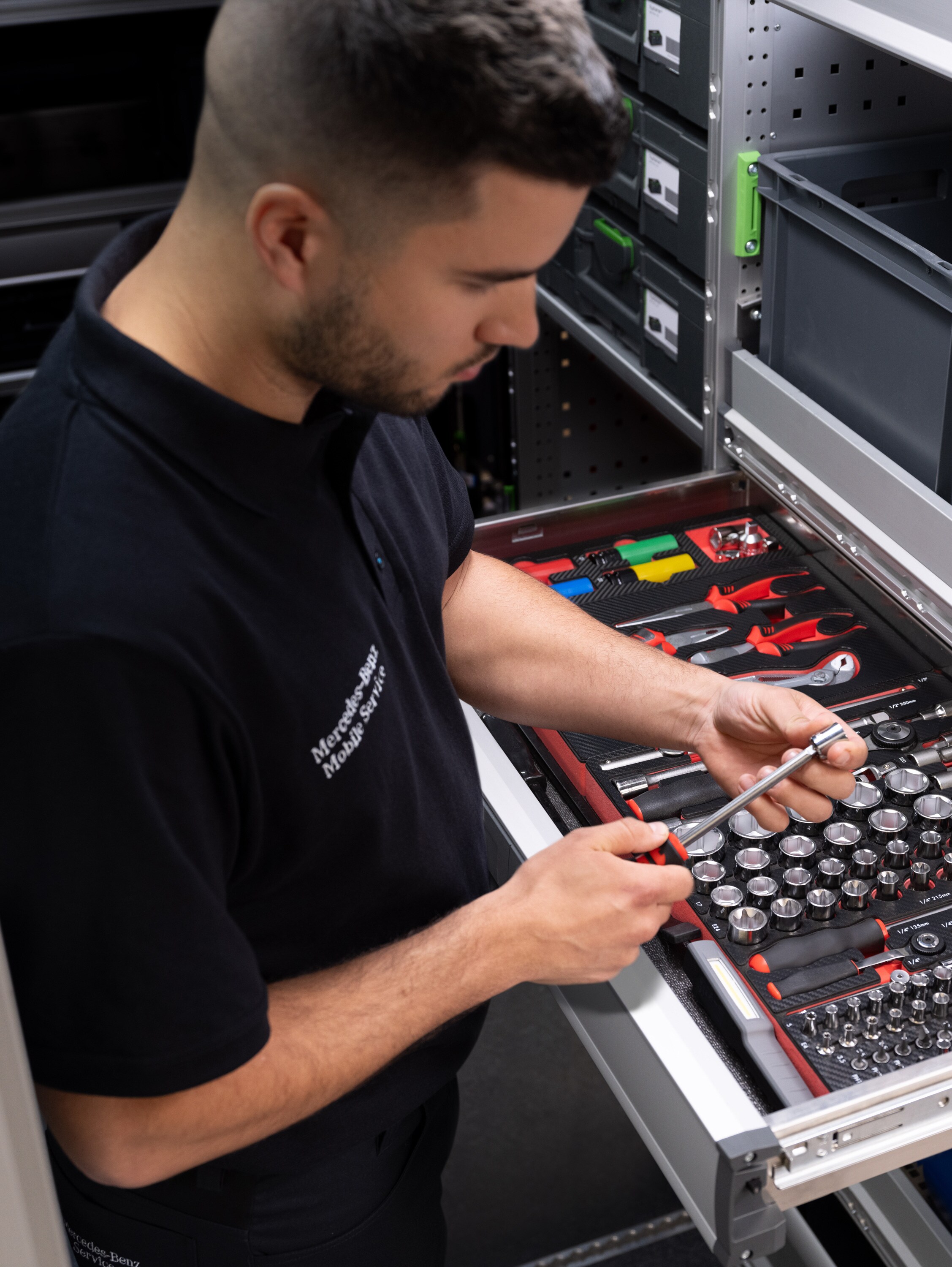 Een technicus kiest een voorwerp uit een lade vol gereedschap.