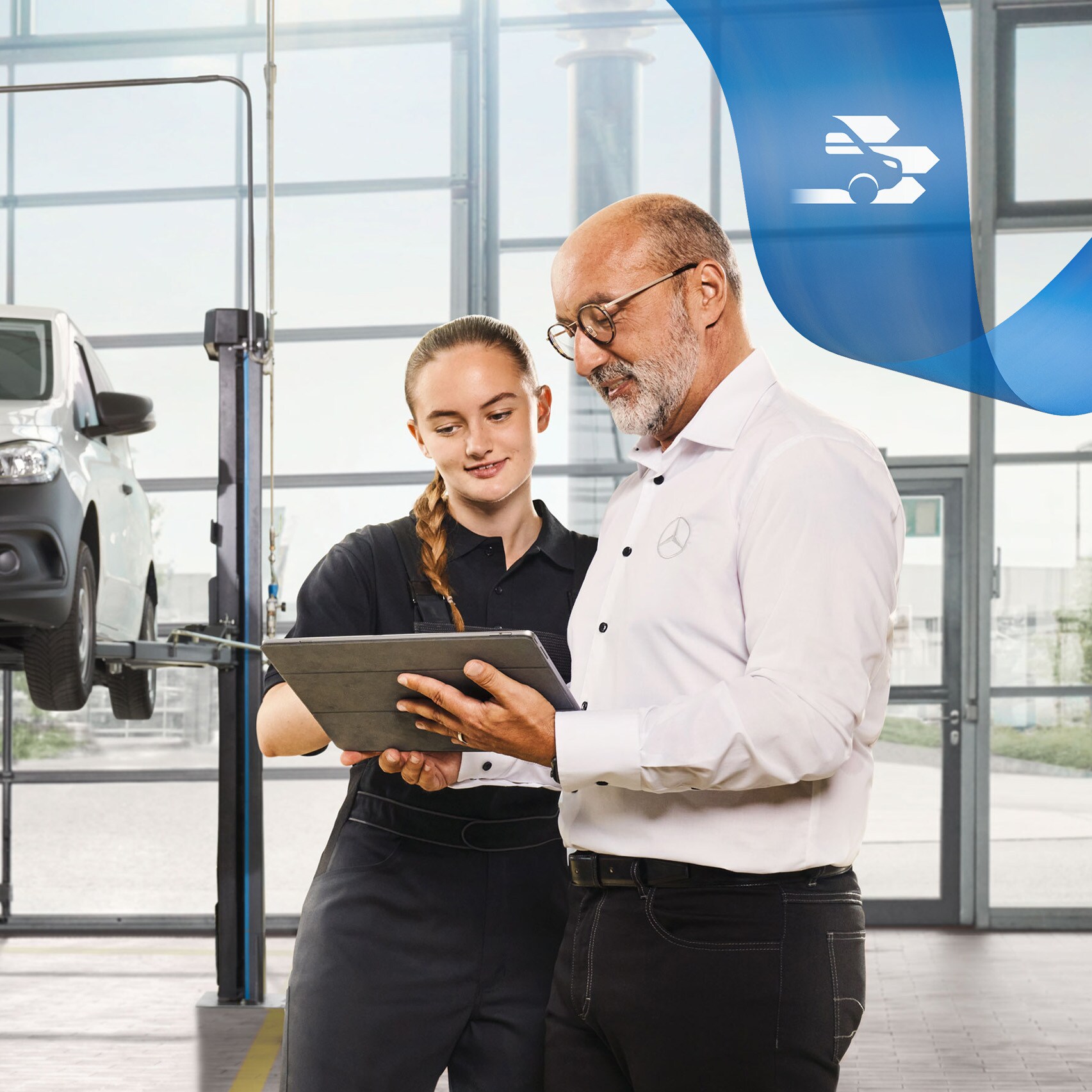 Twee medewerkers bespreken de bedrijfswagenservice bij een opgekrikte Mercedes-Benz bestelwagen in de werkplaats.