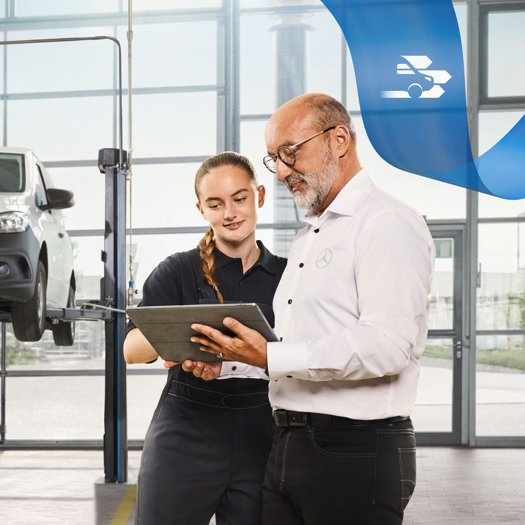 Mercedes-Benz Onderhoud Twee medewerkers bespreken de bedrijfswagenservice bij een opgekrikte Mercedes-Benz bestelwagen in de werkplaats.