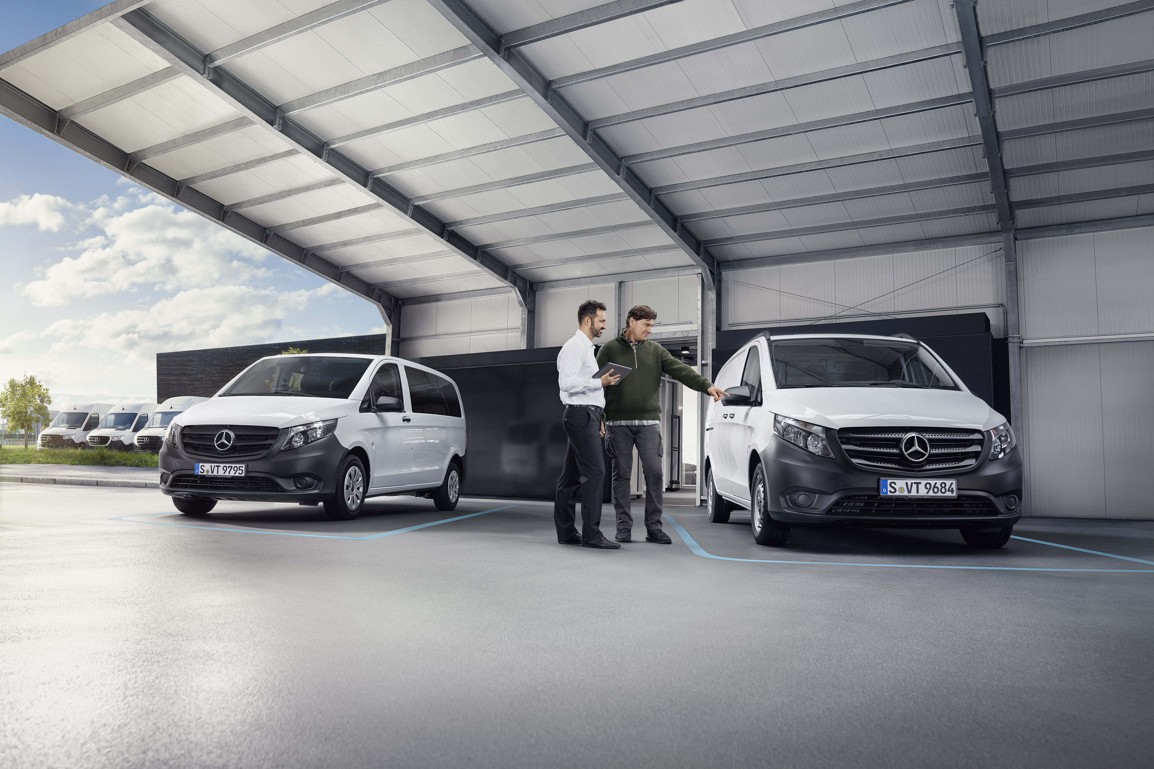 Mercedes-Benz Terugroepactie Mercedes-Benz klantenservicemedewerker met klant op een servicepartnerlocatie voor een bedrijfswagen.