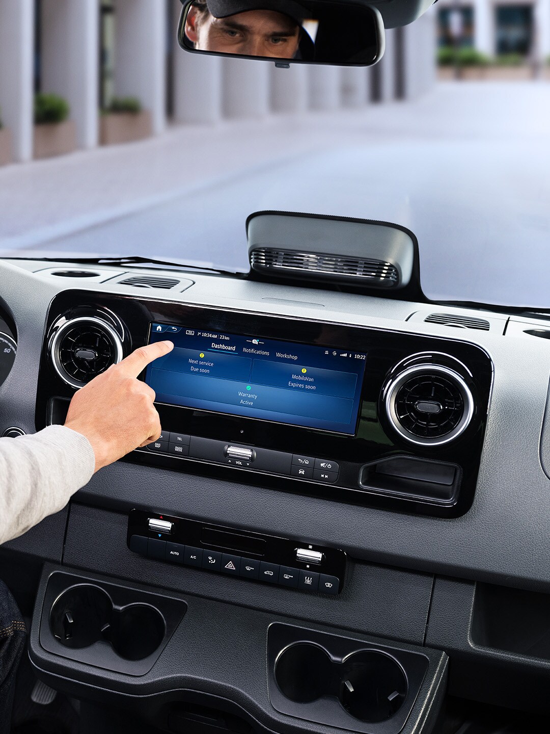 Bestuurder gebruikt Onboard Service App op het display van een Mercedes-Benz bedrijfswagen om voertuiggegevens en serviceopties te bekijken.