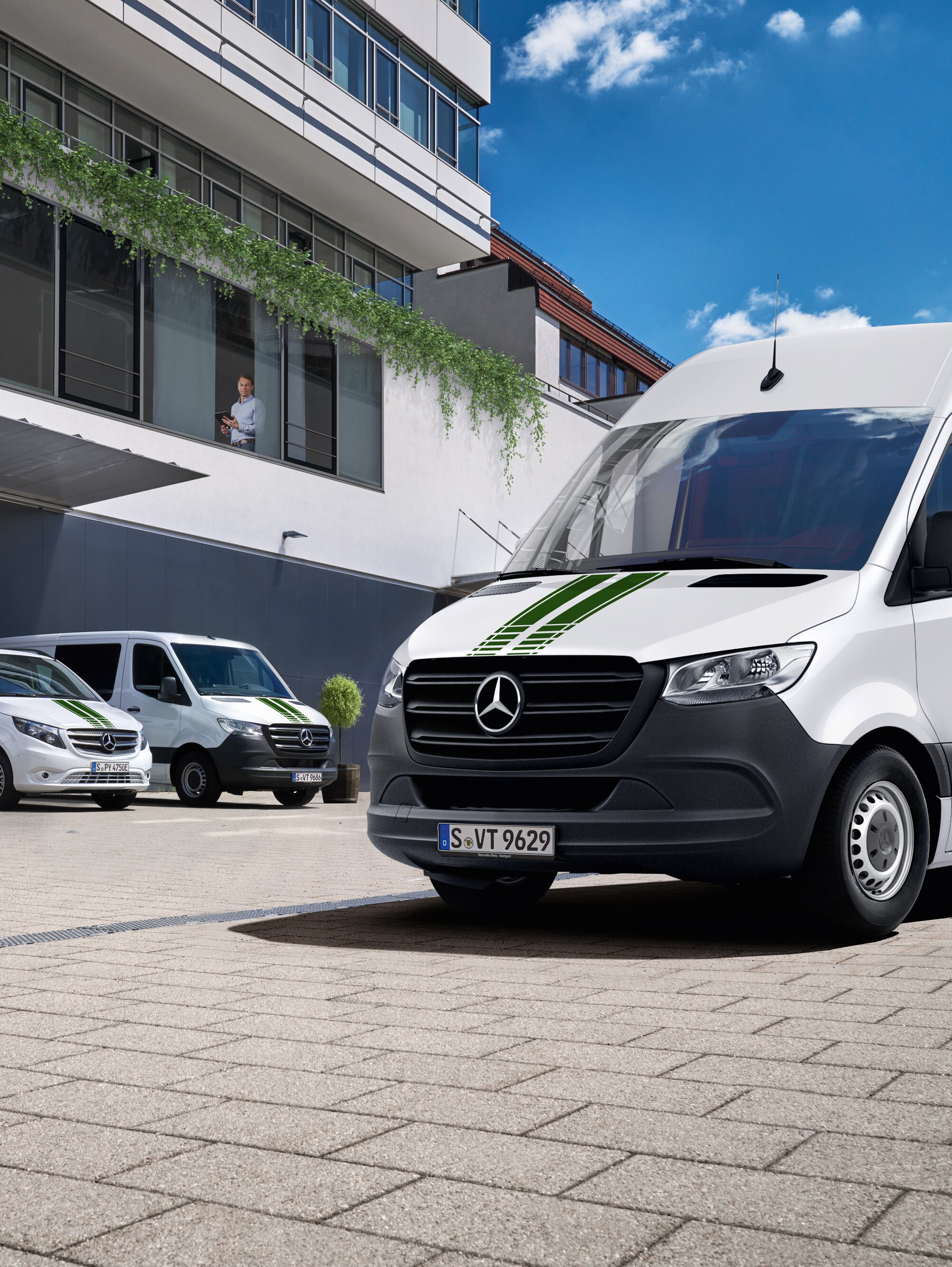 Een wagenpark Mercedes-Benz bestelwagens voor een gebouw, symbool voor digitale wagenparkcontrole.