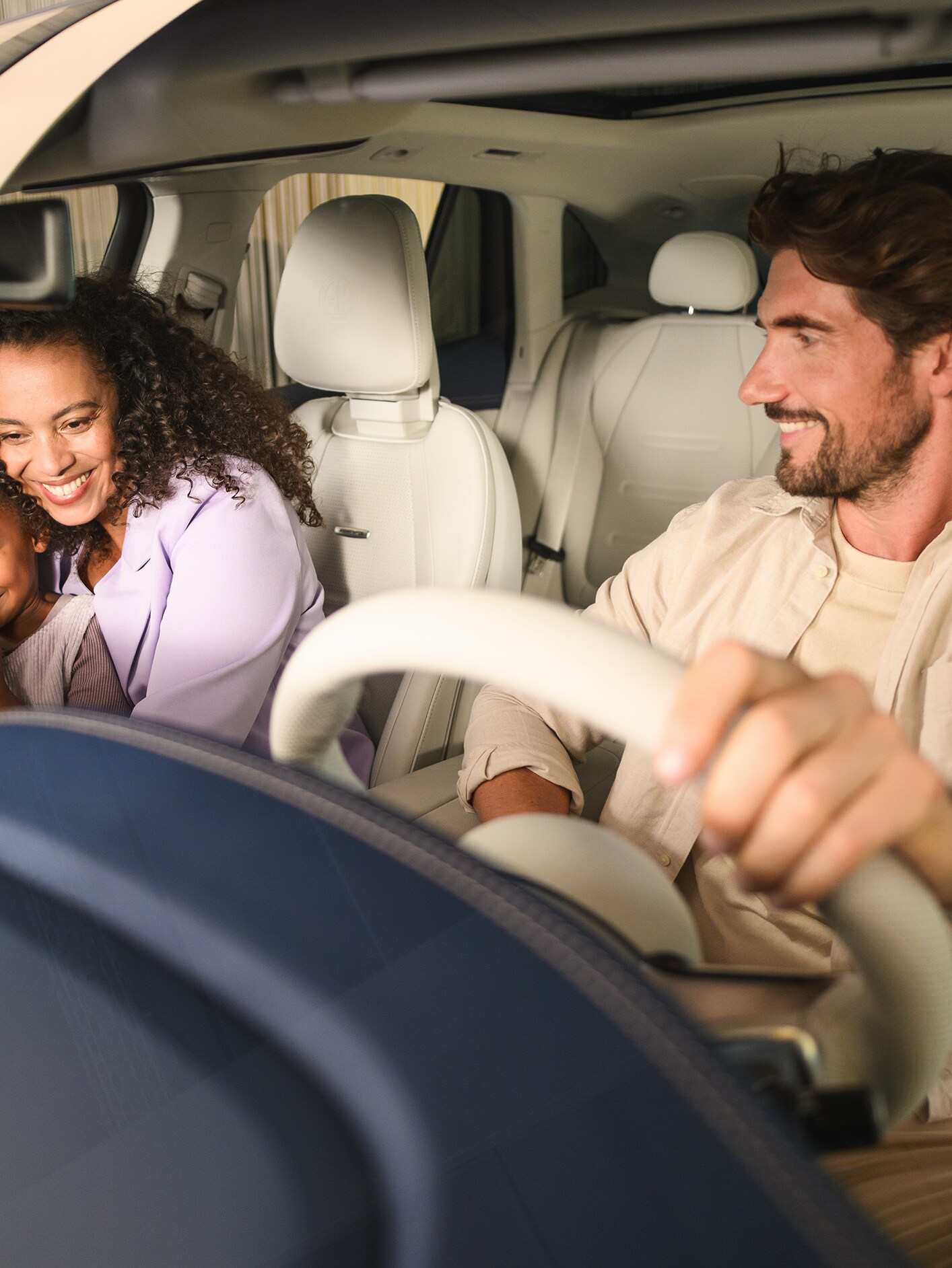 Twee personen en een kind in een Mercedes-Benz voertuig.