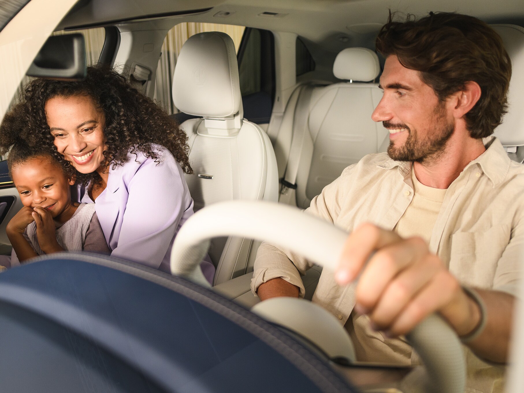 Twee personen en een kind in een Mercedes-Benz voertuig.