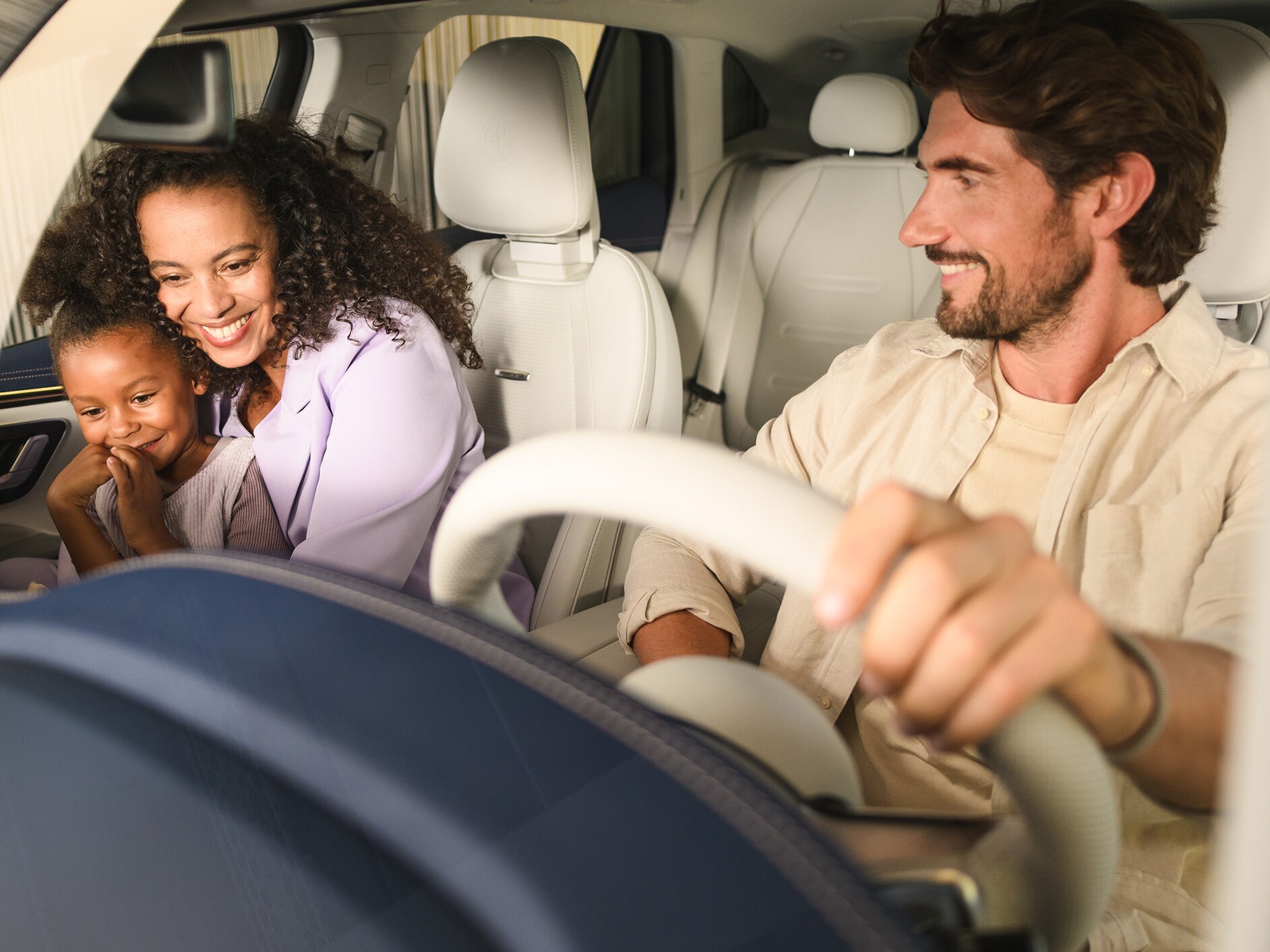 Twee personen en een kind in een Mercedes-Benz voertuig.
