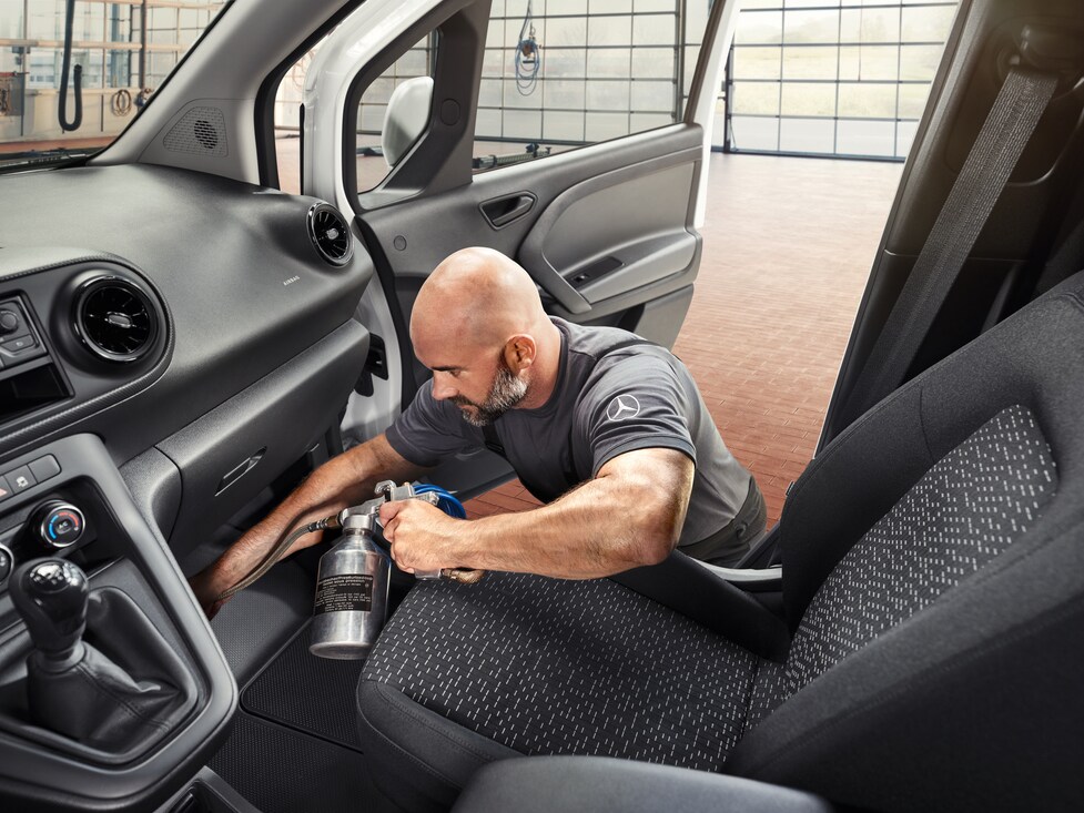 Een Mercedes-Benz technicus reinigt de airconditioning.