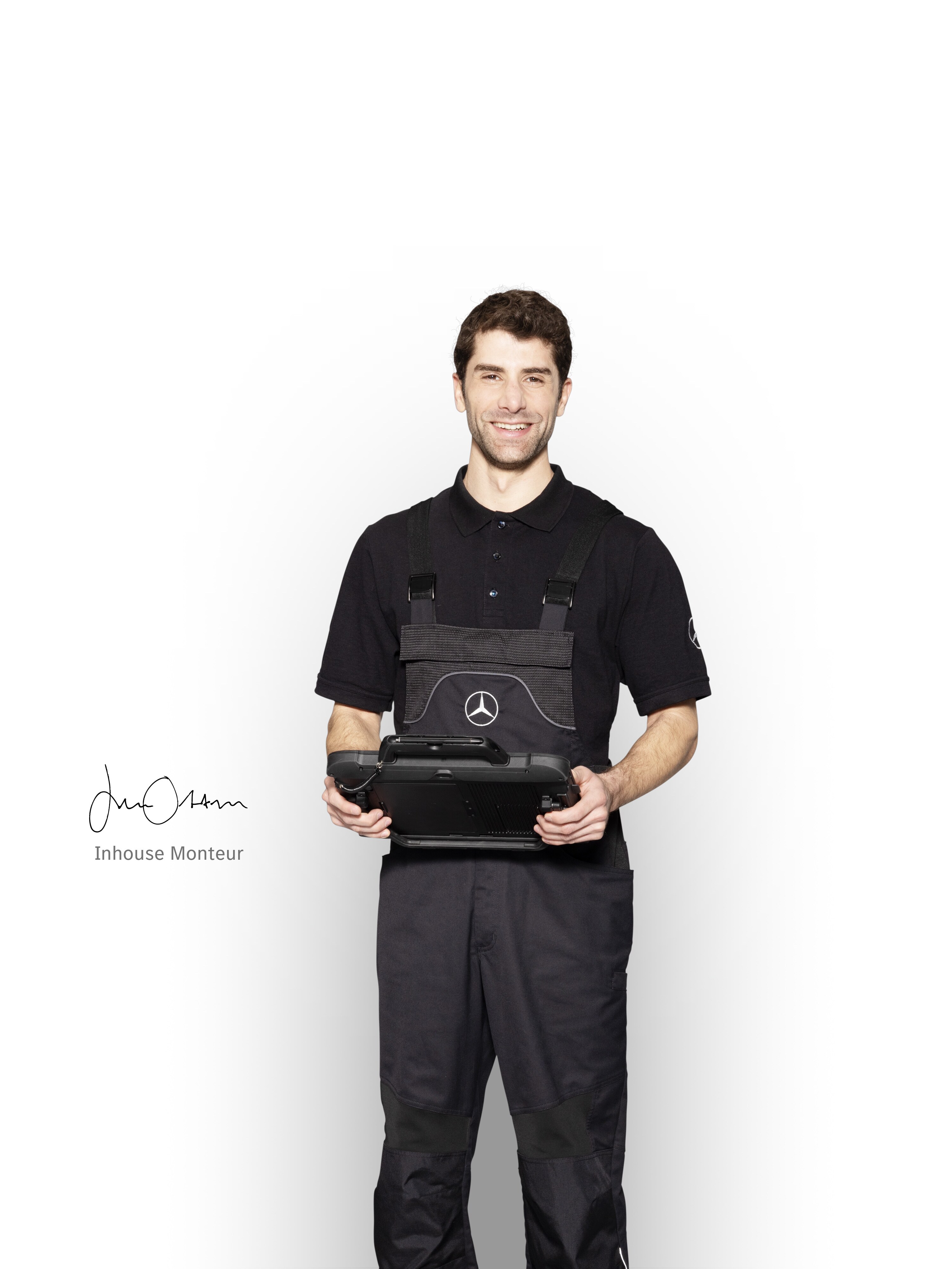 Mercedes-Benz monteur in werkkleding met een tablet in de hand voor het melden van schade.