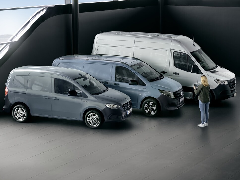 Een vorkheftruck laadt een zwaar voorwerp in een Mercedes-Benz Sprinter Gesloten Bestelwagen op een binnenplaats.