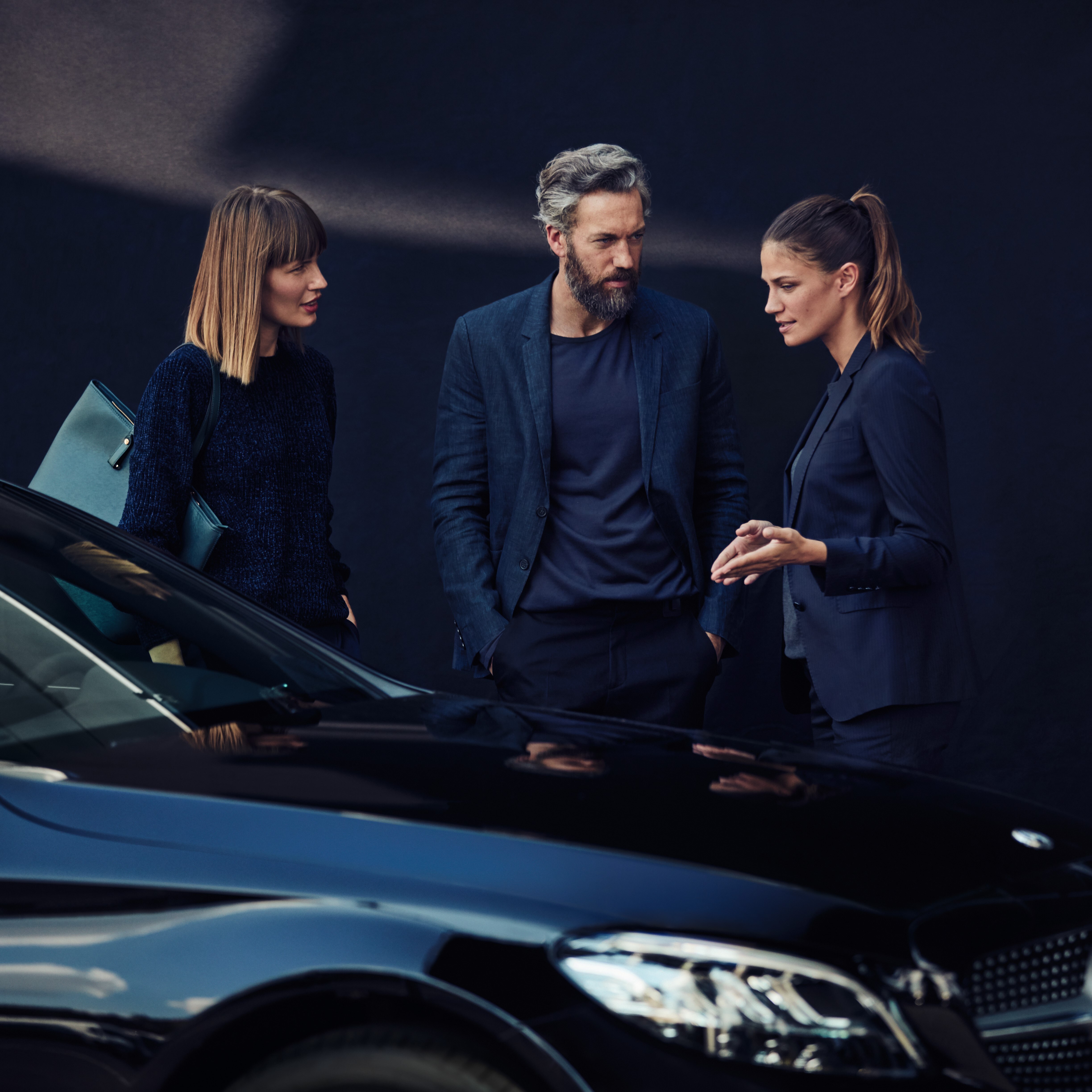 Het beeld toont een Mercedes-Benz E-Klasse op een parking met op de achtergrond gebouwen.